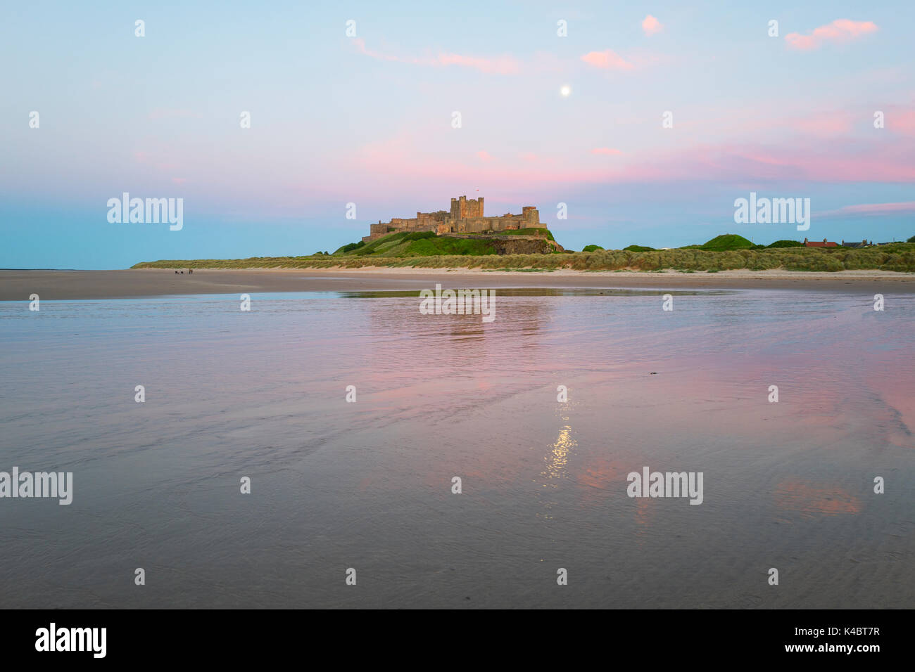 Full Moon Rising oltre il castello di Bamburgh Northumberland Giugno Foto Stock