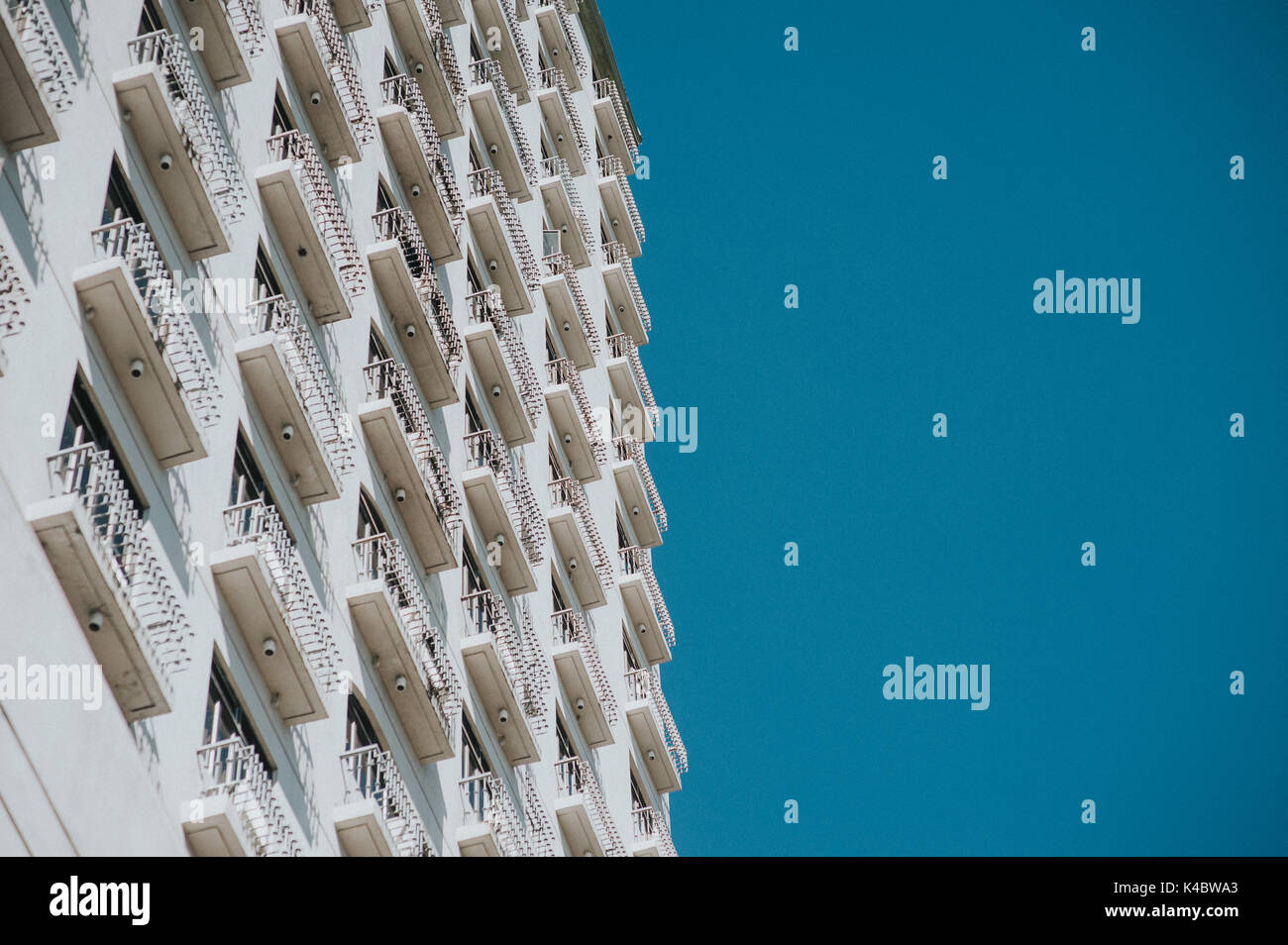 Una metà di un edificio bianco e metà cielo blu. Foto Stock