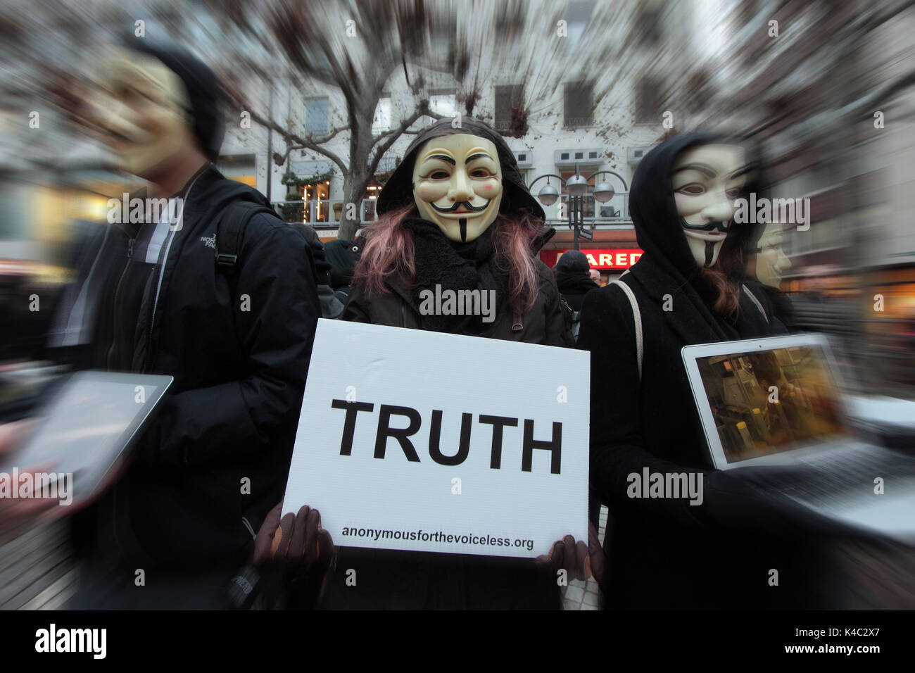 Attivisti anonimi indossando maschere Guy Fawkes tenendo UNA verità segno Foto Stock