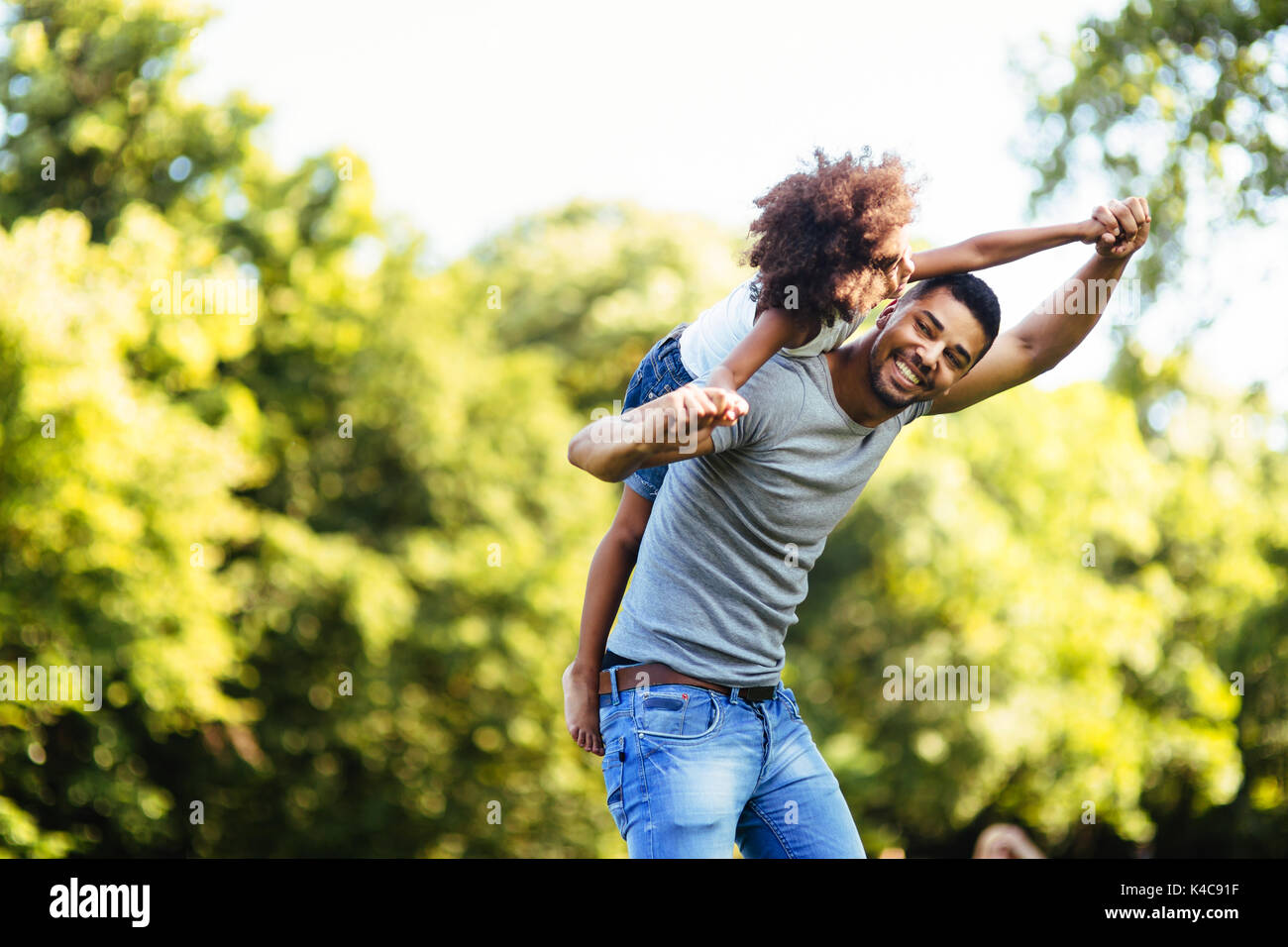 Ritratto di giovane padre portando la sua figlia sul suo retro Foto Stock
