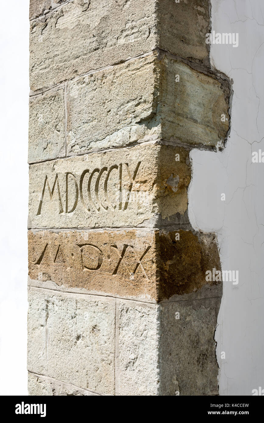 Antico borgo medievale contrafforte dettaglio con numeri romani. Texture di pietra. Foto Stock