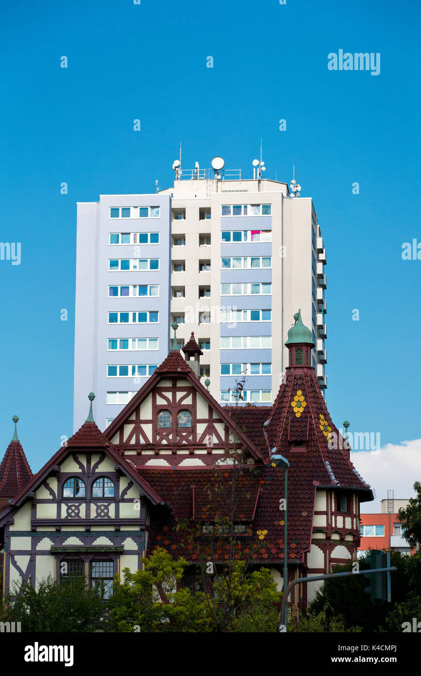 Vecchio legno incorniciata house di fronte al grattacielo moderno Foto Stock