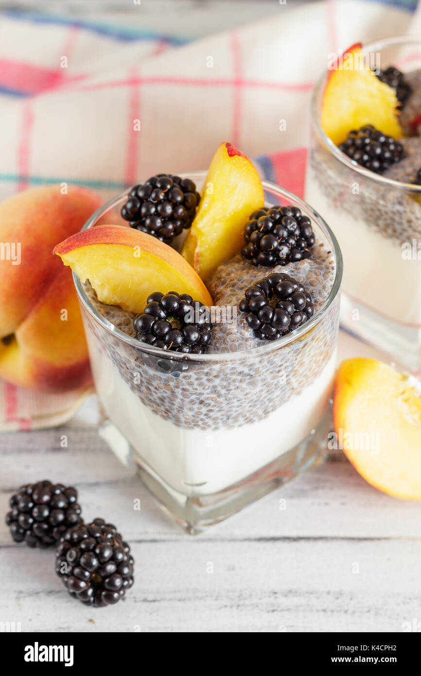 Chia budino di sementi con yogurt, pesche e more. Sana colazione o spuntino mattutino concept Foto Stock