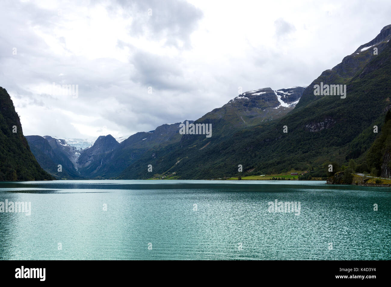 Barca a vela su un fiordo norvegese con un ghiacciaio in background Foto Stock