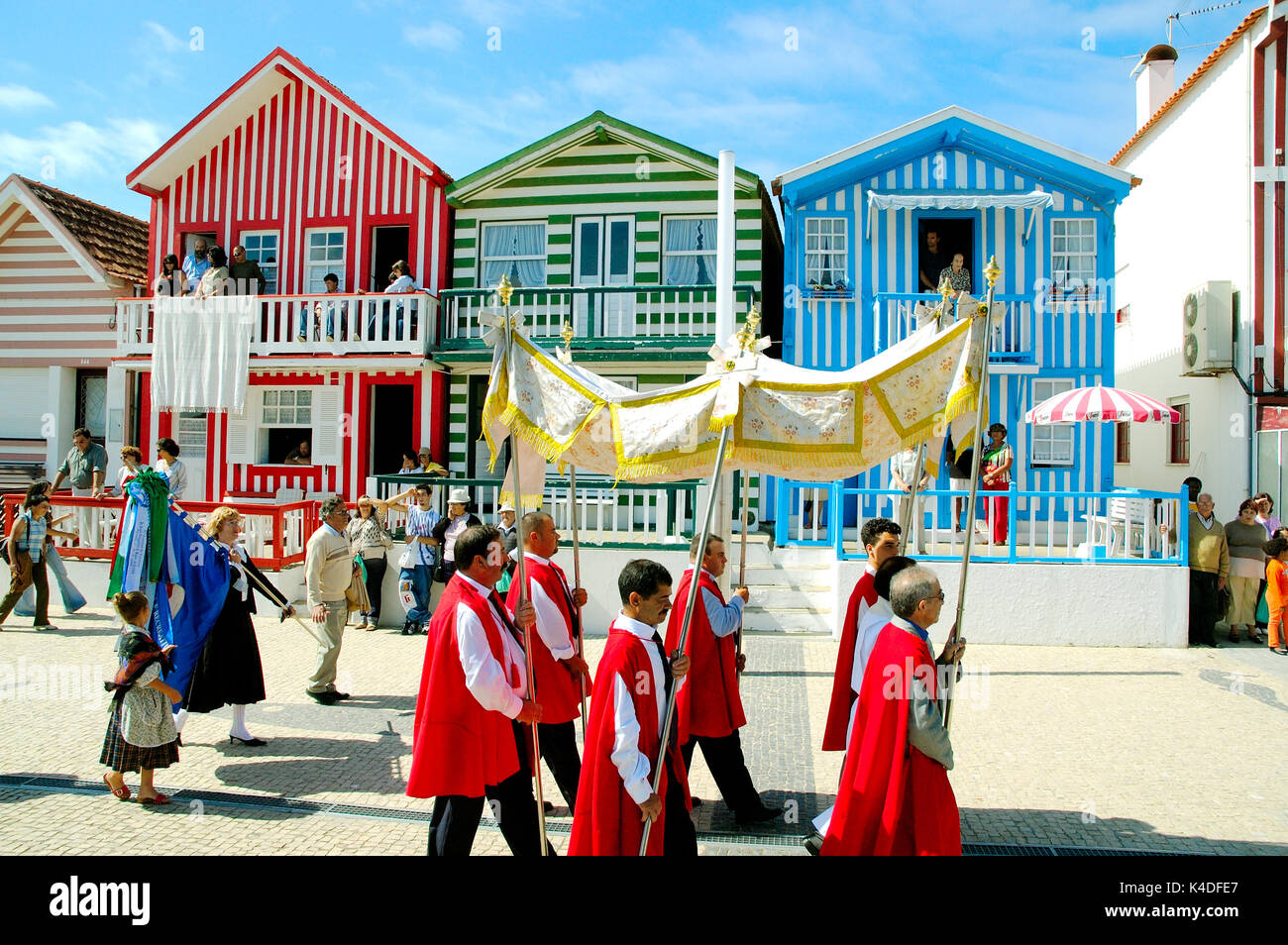 Processione religiosa durante la tradizionale festa di Nossa Senhora da Saúde. Sullo sfondo le tradizionali case di legno di Costa Nova, Portog Foto Stock