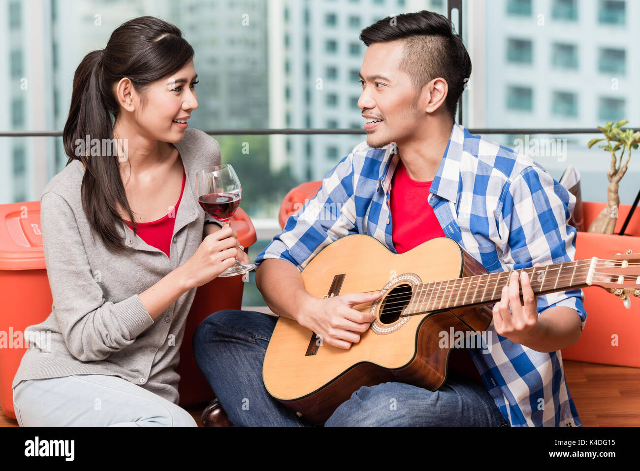 Dopo lo spostamento insieme giovane uomo gioca love song per la sua girlfrie Foto Stock