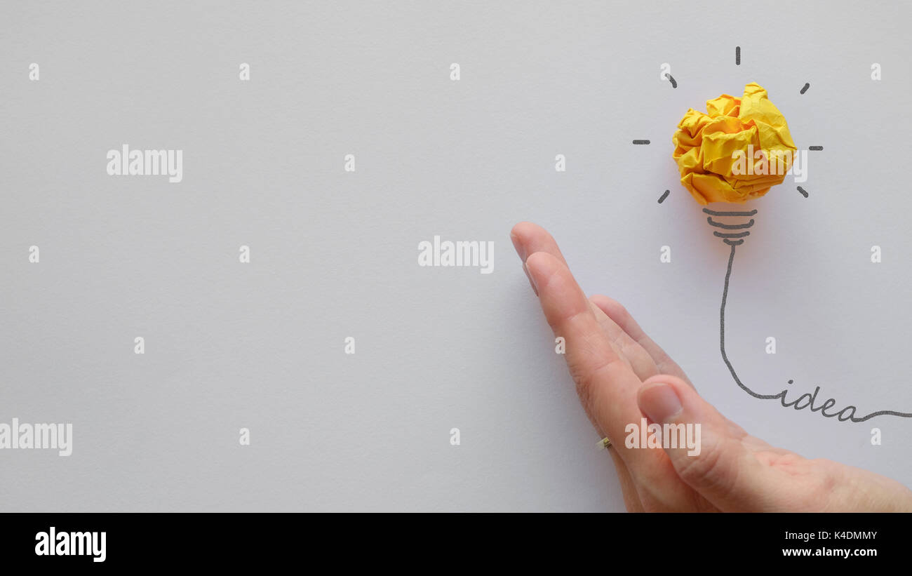 Carta gialla lampadina a portata di mano, innovativo, il pensiero creativo la concezione di business Foto Stock
