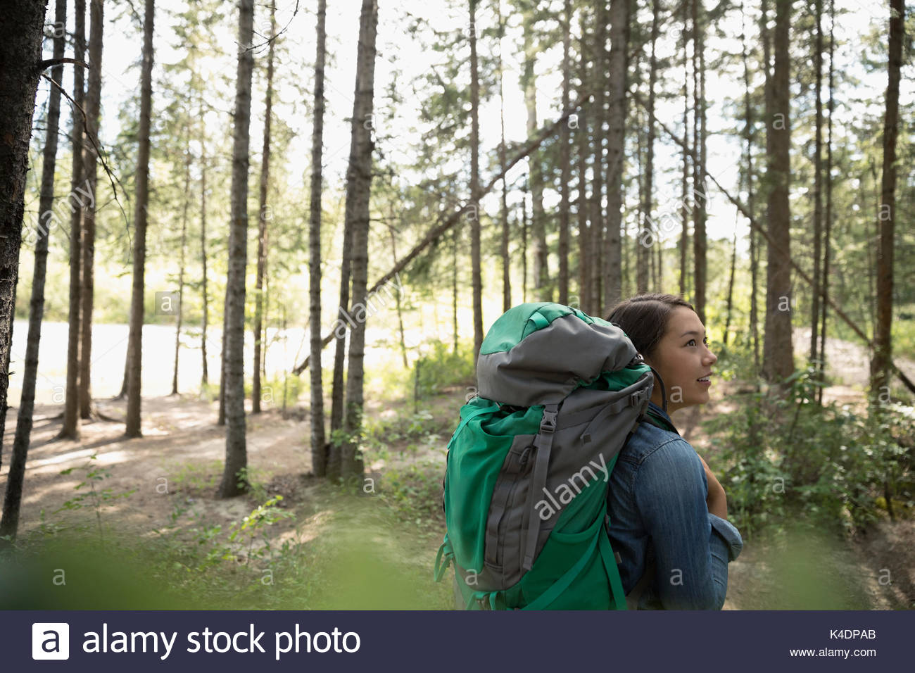 Curioso ragazza adolescente con zaino escursioni nei boschi Foto Stock