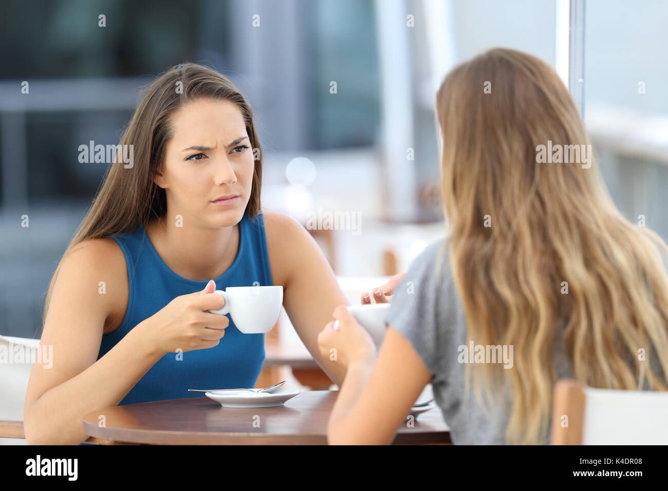 Due gravi amici avente una conversazione seduto in un bar terrazza Foto Stock