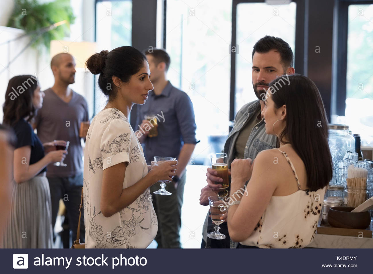 Gli amici a bere il vino e la birra, di conversazione e di socializzazione in bar Foto Stock
