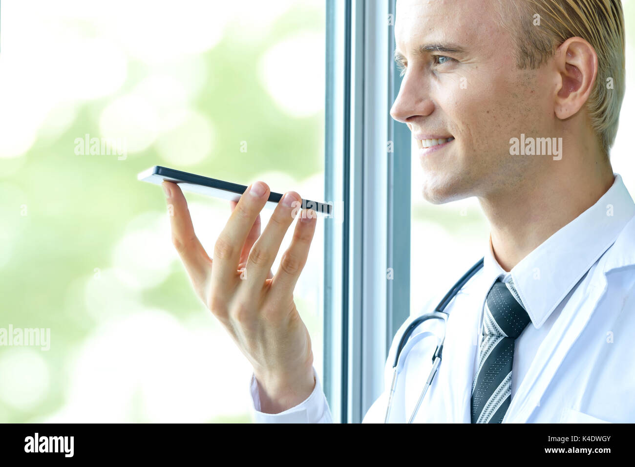 Riconoscimento vocale , biometrici discorso rilevare nel settore sanitario concetto tecnologico. Medico parla allo smartphone per ordine di comando in ospedale. Foto Stock