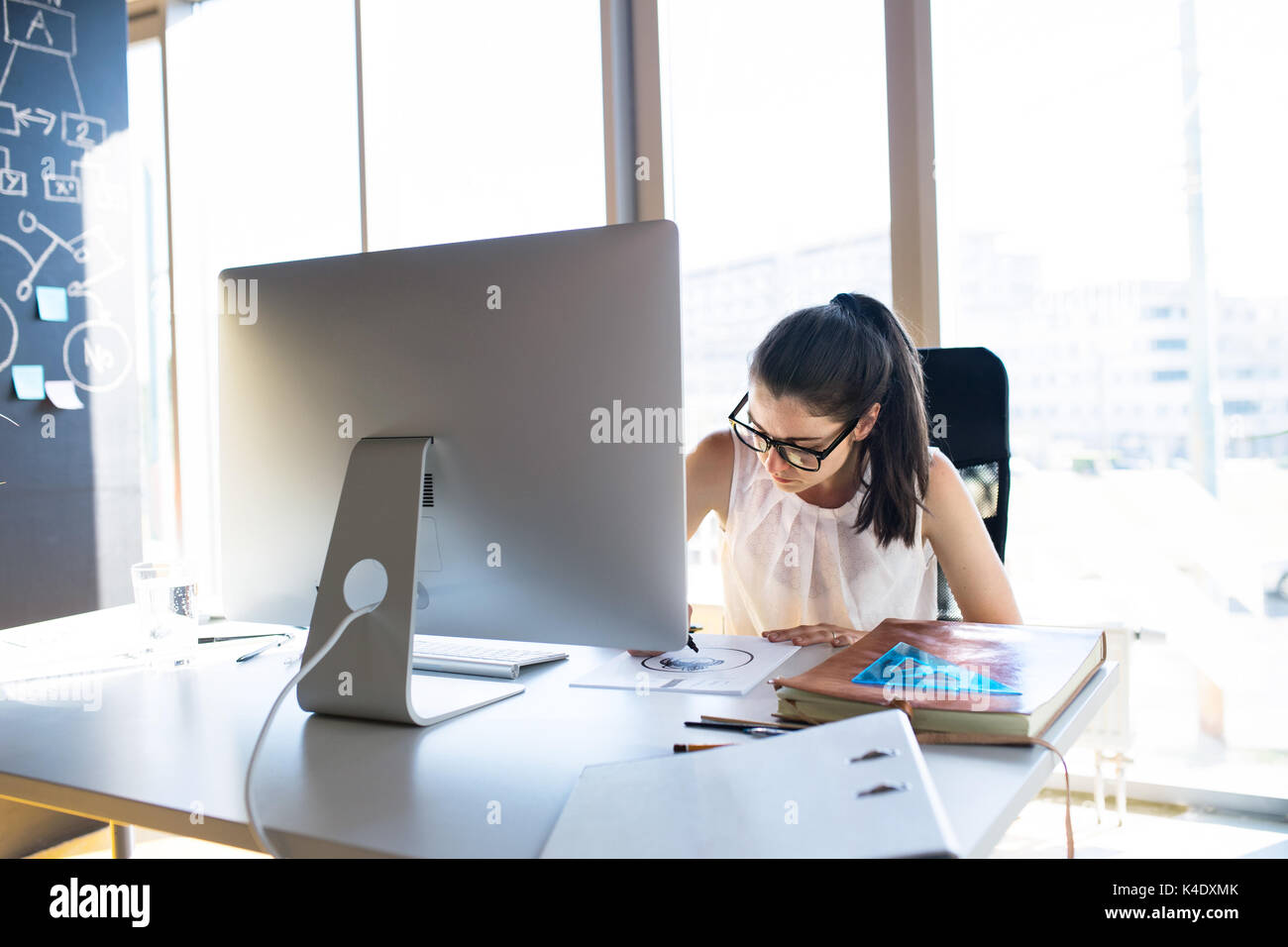 Imprenditrice con il computer nel suo ufficio, lavorando. Foto Stock