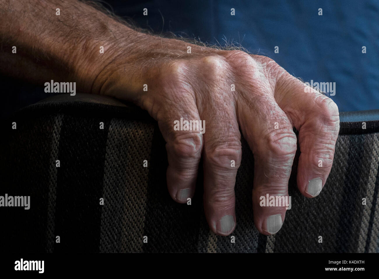 A mano - un primo piano della mano di una persona anziana e tenendo la schiena di una sedia. Foto Stock