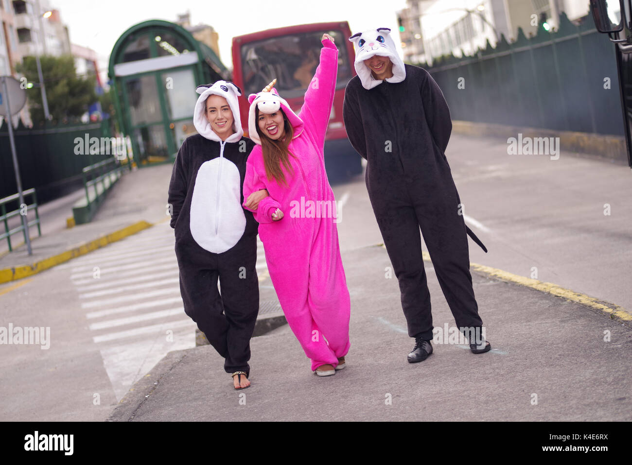 In prossimità di un buon gruppo di amici indossando costumi diversi, una donna che indossa un unicorno rosa costume, altra donna un panda costume e l'uomo che indossa un costume da gatto, nella città di Quito Foto Stock