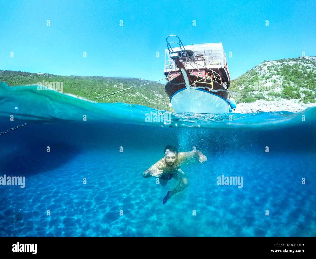 L'uomo le immersioni subacquee. metà foto subacquee con sky e isola. Foto Stock