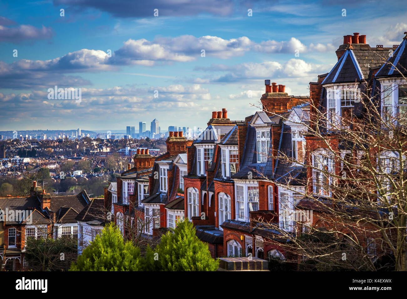 Londra, Inghilterra - Vista panoramica dello skyline di Londra e dei grattacieli di Canary Wharf con tradizionali case in mattoni inglesi Foto Stock
