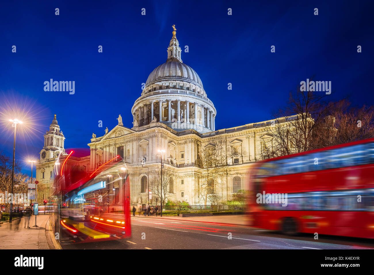Londra, Inghilterra - Splendida cattedrale di Saint Paul con gli iconici autobus rossi a due piani in movimento di notte Foto Stock