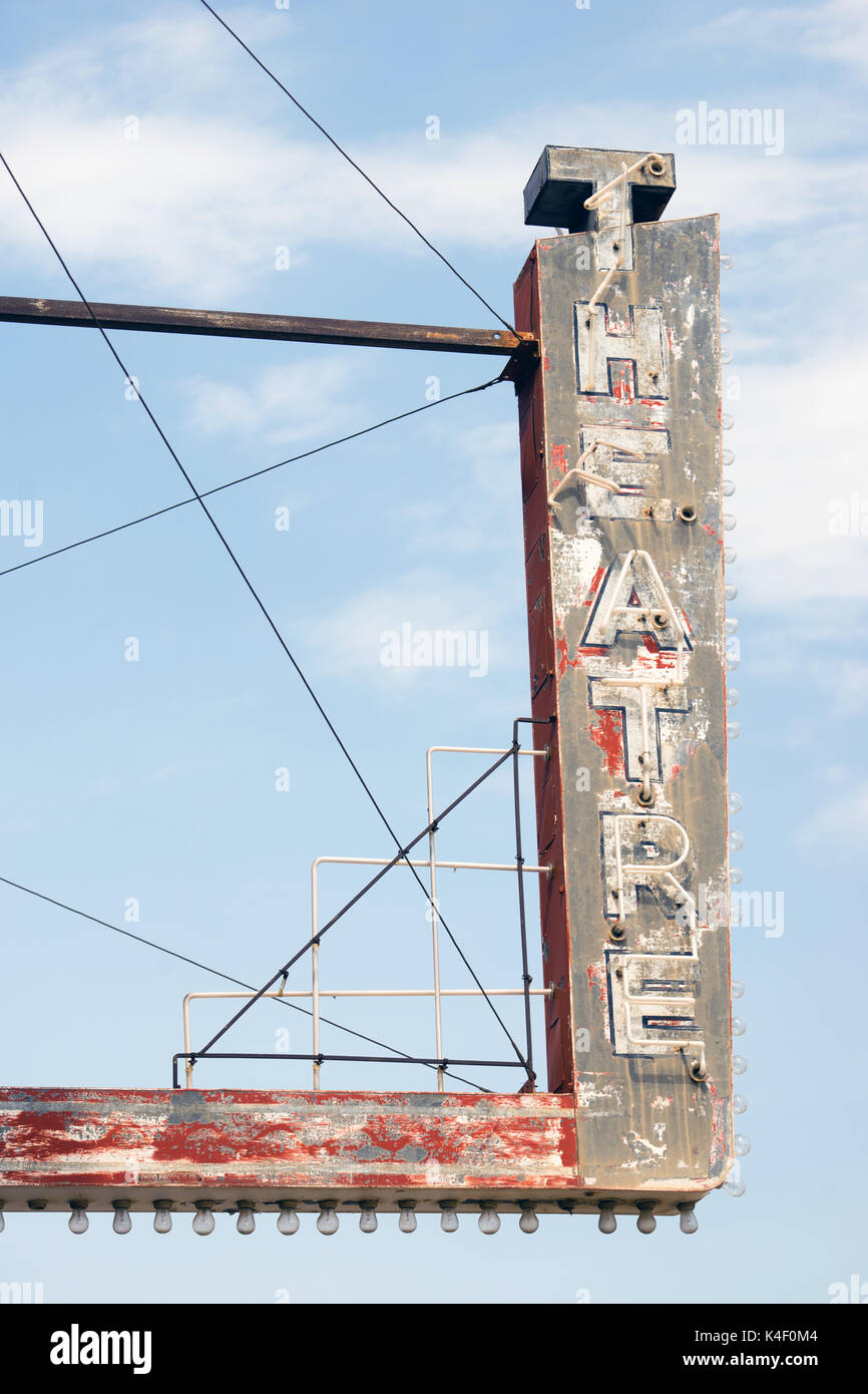 Composizione verticale di metallo teatro neon segno contro il cielo blu Foto Stock