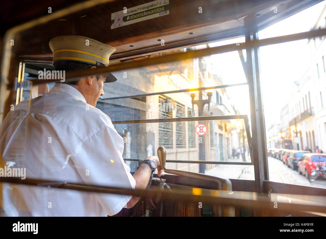 Conduttore maschio di un tram d'epoca restaurato del 1911 durante un tour nella città di Santos, Stato di San Paolo, Brasile. Foto Stock