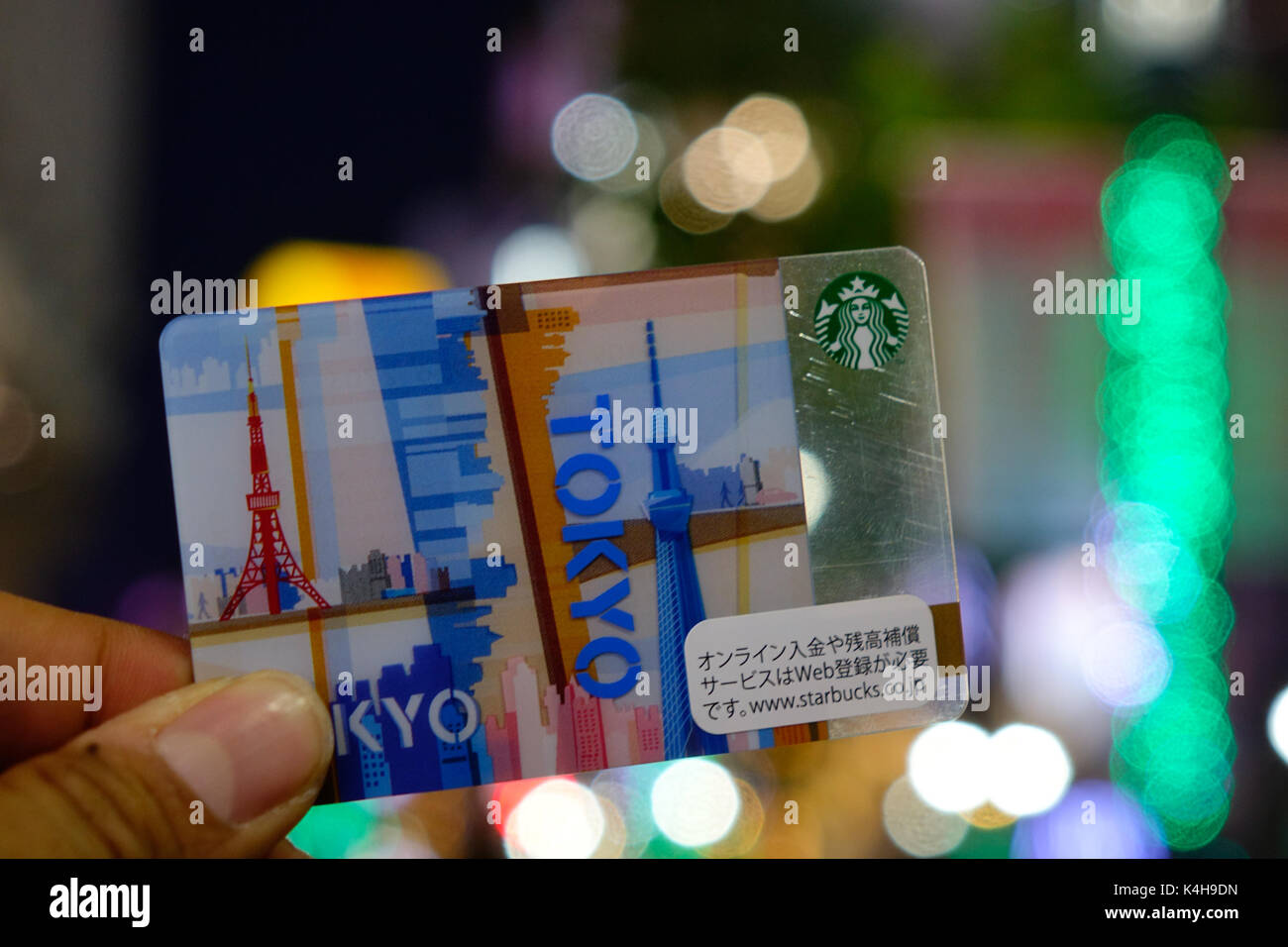 Tokyo, Giappone - Jan 4, 2016. Mano azienda Starbucks carta fedeltà con luce sfondo bokeh di fondo nel quartiere di Ginza, Tokyo, Giappone. Foto Stock