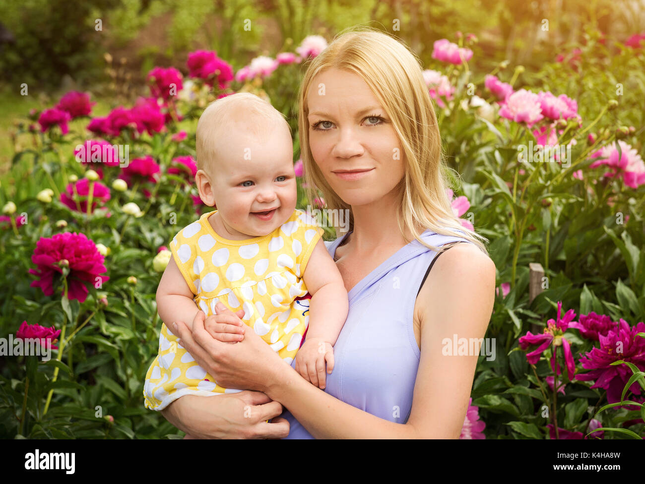 Felice donna e bambino in fioritura peonia fiori Foto Stock