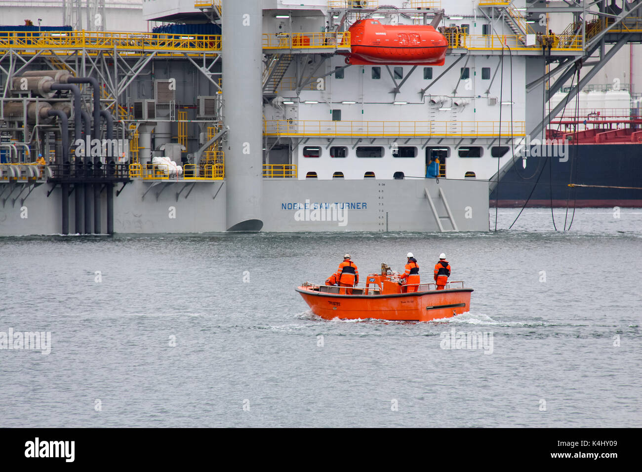 Caland canal, Rotterdam, Paesi Bassi, 29 maggio 2014: l'equipaggio della dockwise semi-sommergibile nave a vela in un piccolo workboat Foto Stock