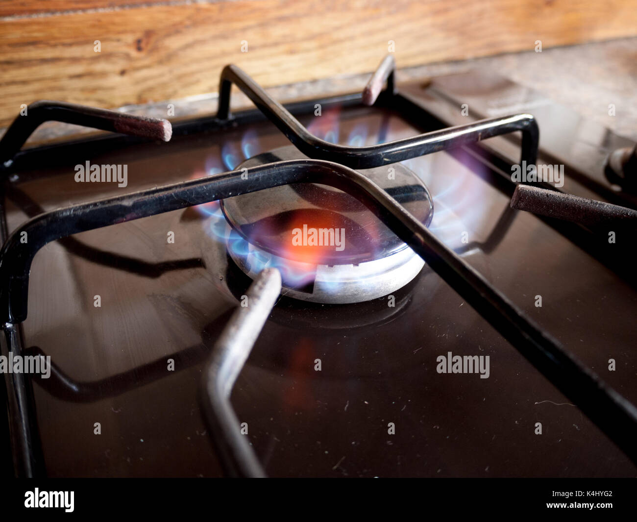 Un piccolo piano di cottura a gas a forma di anello si accende con una fiamma blu Foto Stock