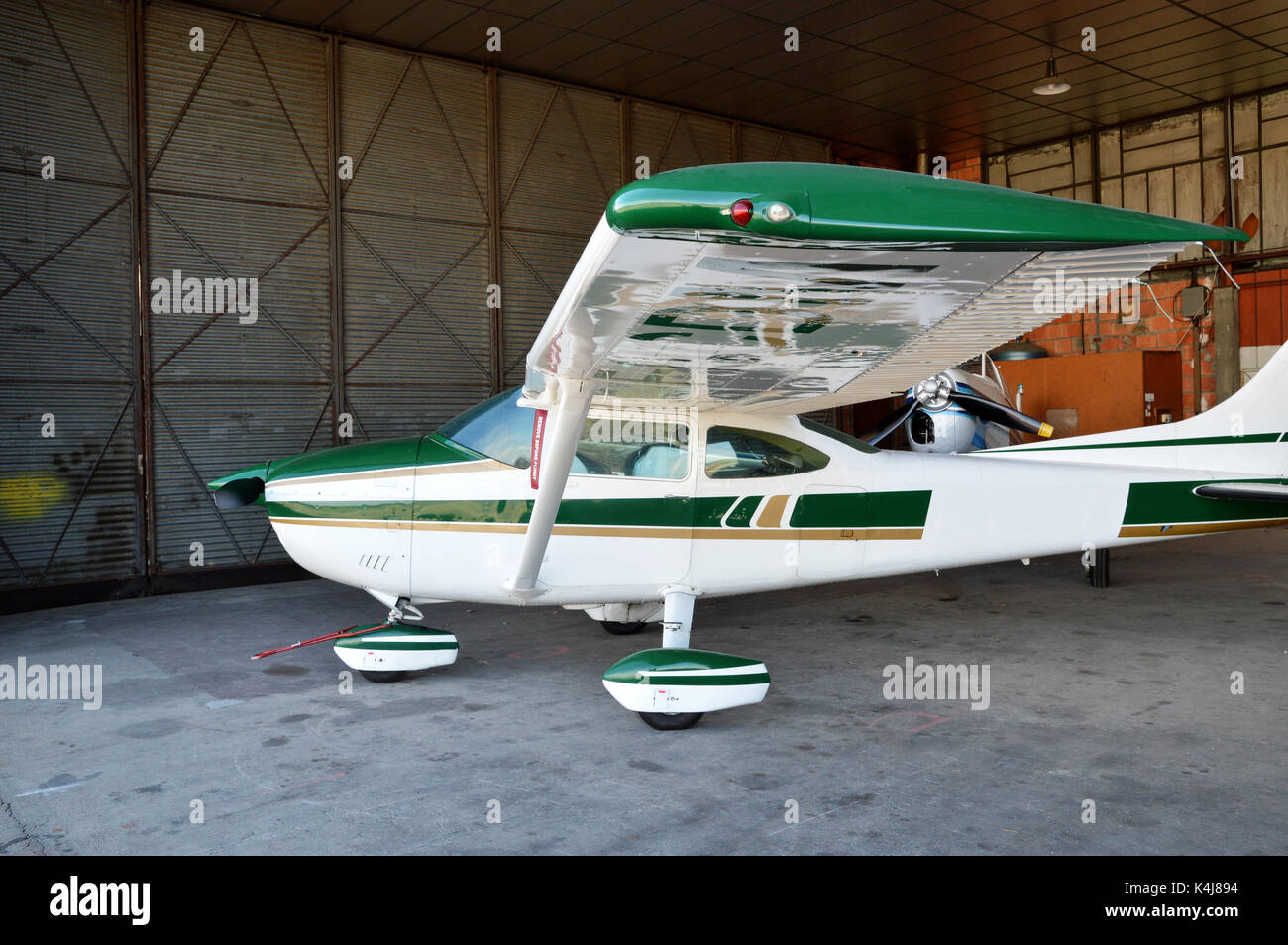 Un piccolo aereo parcheggiati in hangar aereo. Foto Stock