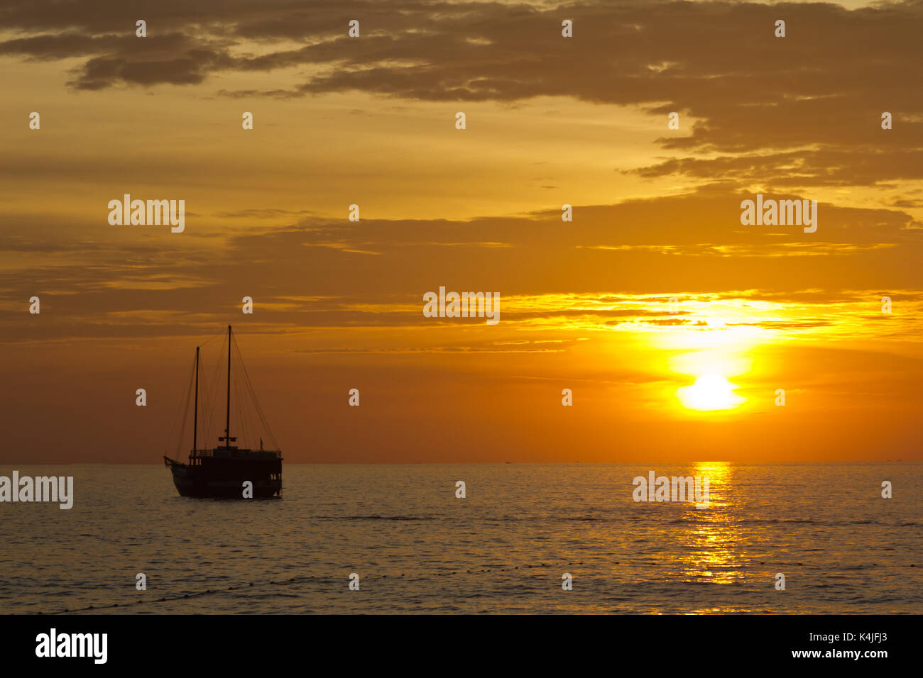 Silhouette in barca al tramonto, Surin Beach, Phuket, Tailandia Foto Stock