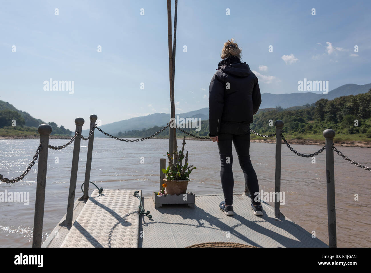 Vista posteriore della donna in piedi sul dock, fiume Mekong, Laos Foto Stock