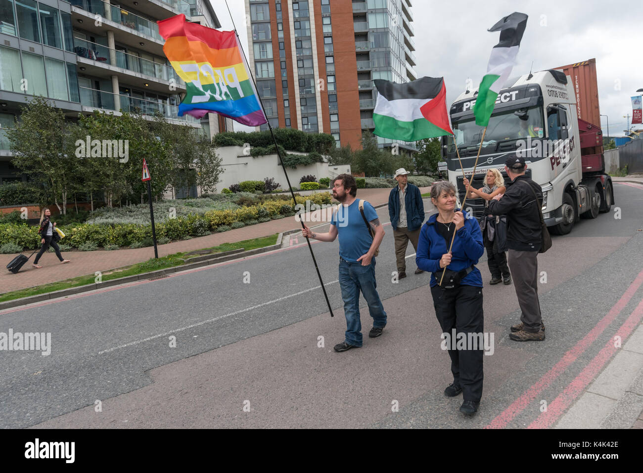 5 settembre 2017 - Londra, Regno Unito - Londra, Regno Unito. 5 settembre 2017. Le persone camminano lentamente con le bandiere di fronte ad un camion che vanno verso il West Gate nel mondo la più grande fiera di armi detenute nelle Docklands di Londra sul 'Nessuna fede in guerra " giorno di proteste organizzate da diversi gruppi di fede. Prima del mio arrivo vi era stato un lock-in sull'approccio road arrestando le consegne provenienti per impostare il giusto attraverso la porta est. Questa è stata seguita da una riunione di Quaker a lato della strada durante la quale un certo numero di persone che stavano in piedi o seduto per bloccare la strada e diversi che si è rifiutato di muoversi erano stati arrestati. Quindi quattro prote Foto Stock