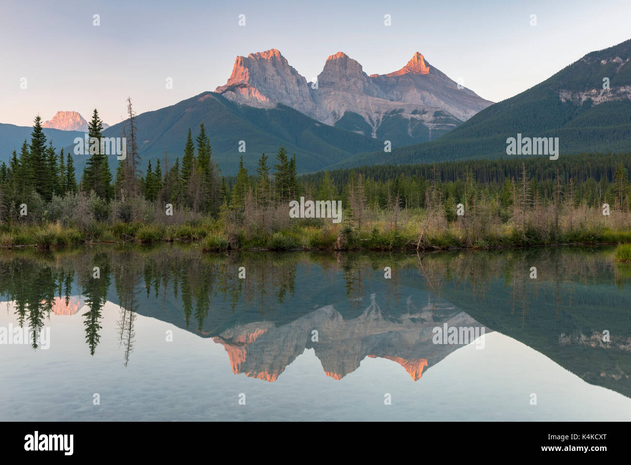 Le tre sorelle riflettendo in acque calme, Atmosfera mattutina, il fiume Bow, Canmore, il parco nazionale di Banff, Alberta, Canada Foto Stock