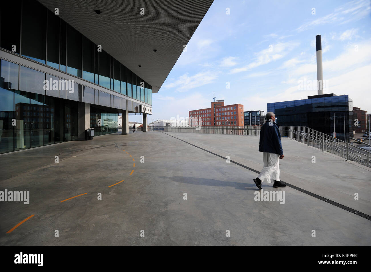 Un uomo a piedi dall'entrata alla Dokk1, una nuova cultura e casa multimediale ad Aarhus in Danimarca. Foto Stock