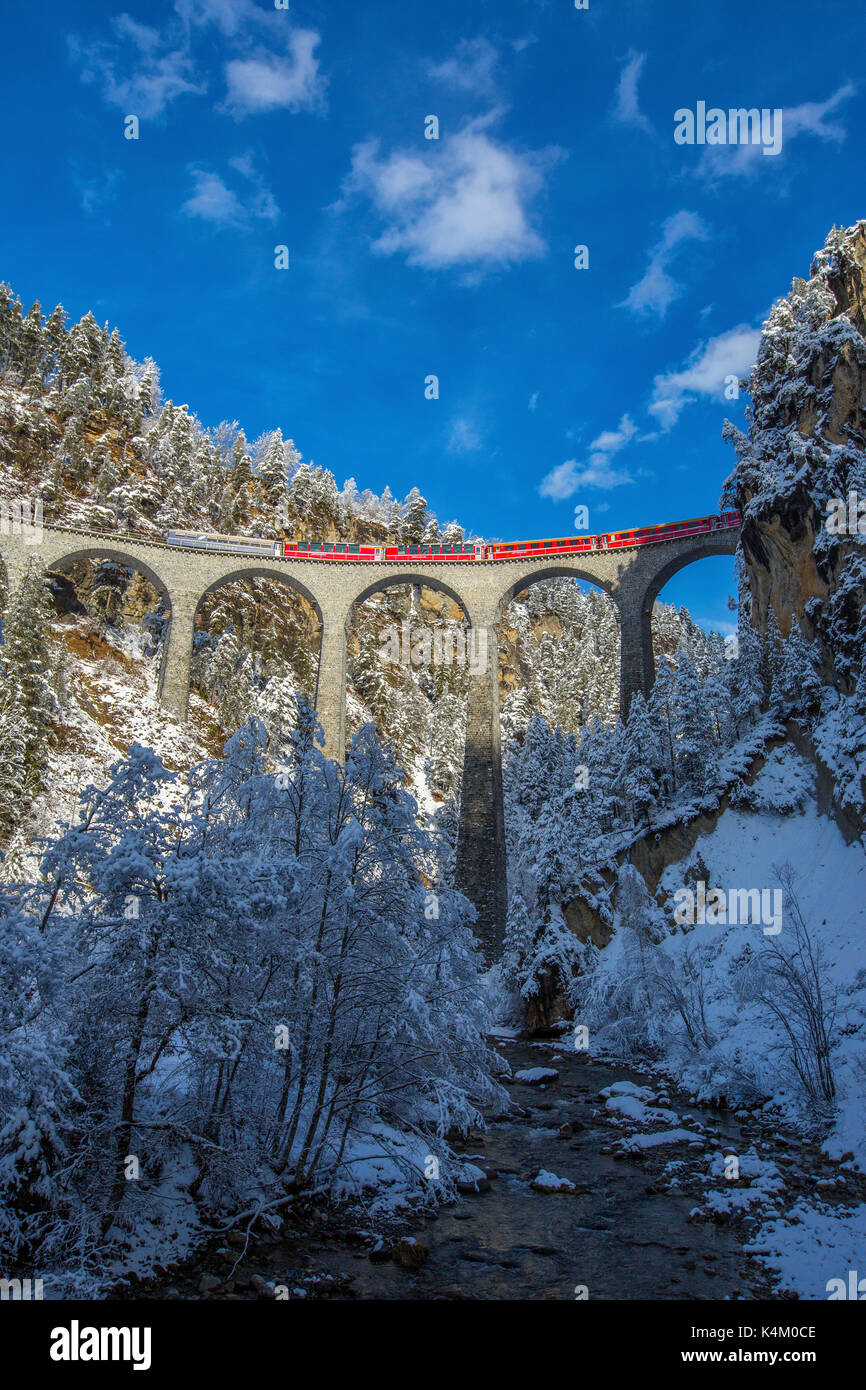 Bernina Express passa attraverso i boschi innevati intorno a Filisur Cantone dei Grigioni Svizzera Europa Foto Stock