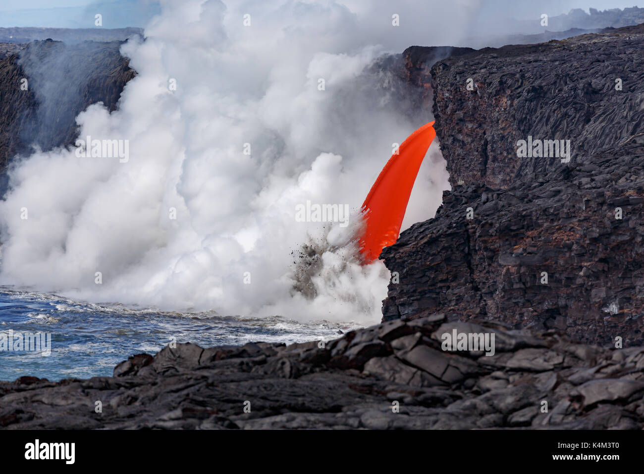 Vista ingrandita del rosso di lava fusa di un vulcano attivo da una cima in hawaii national park scorre come un tubo antincendio la massiccia nube di st Foto Stock