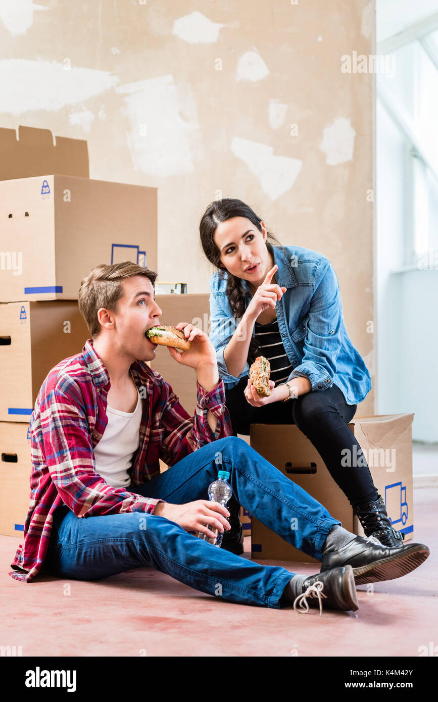 Coppia giovane cerca stanco mentre mangiare un panino durante la pausa Foto Stock