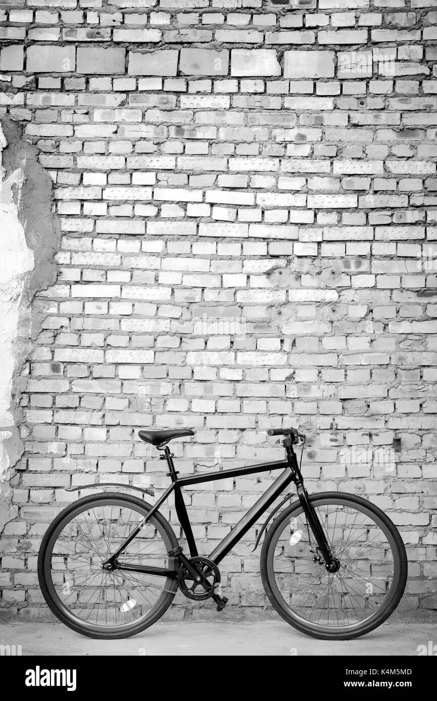 Nero moto contro un muro di mattoni. foto in bianco e nero Foto Stock