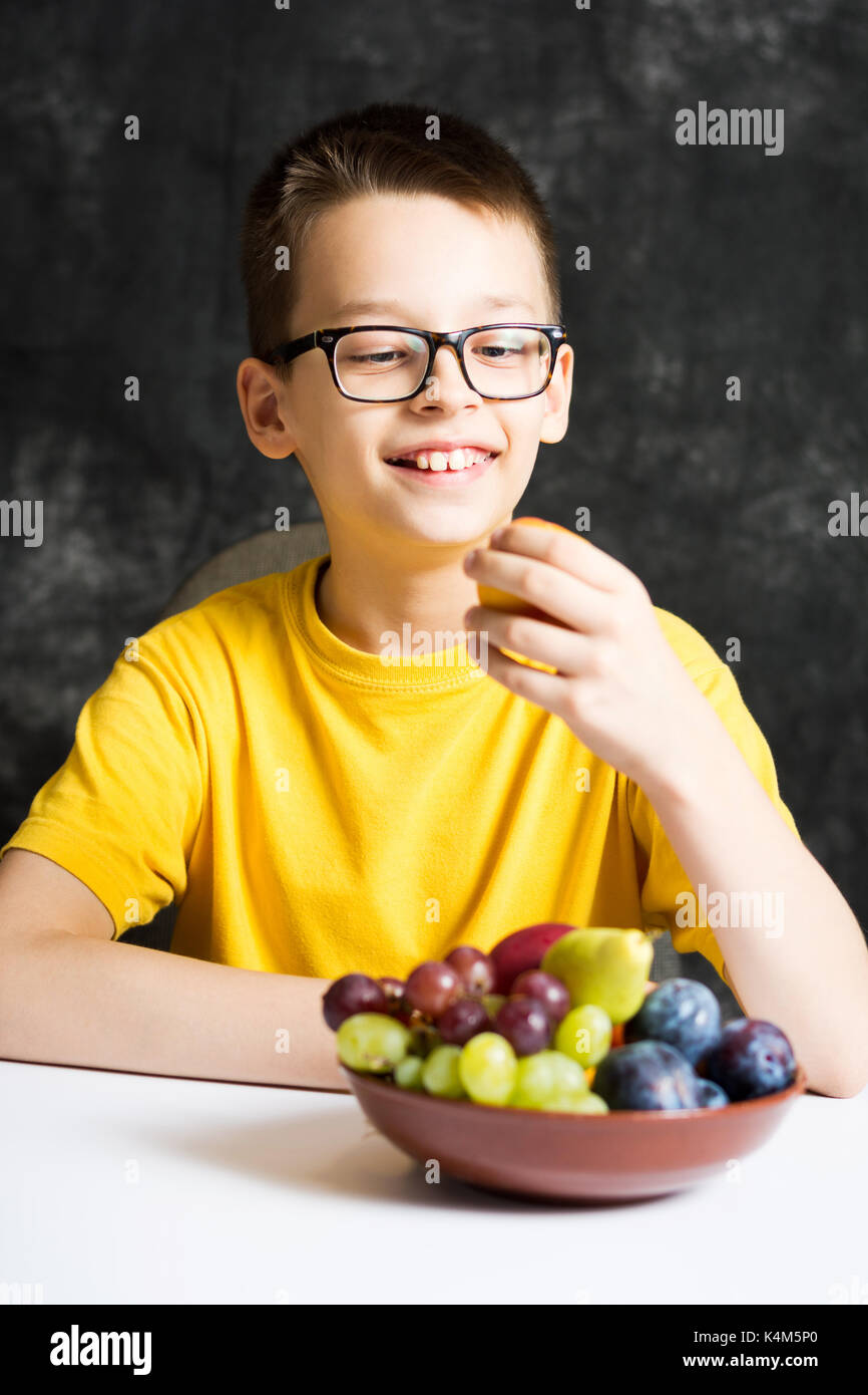 Ragazzo adolescente mangiare la frutta per un snack sani Foto Stock