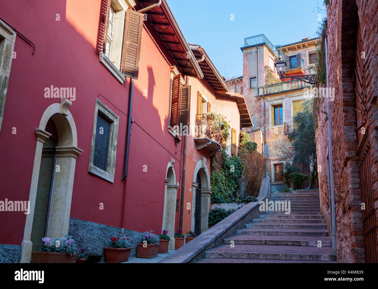 Strada stretta con case colorate lungo la strada per il castel san pietro, verona Foto Stock
