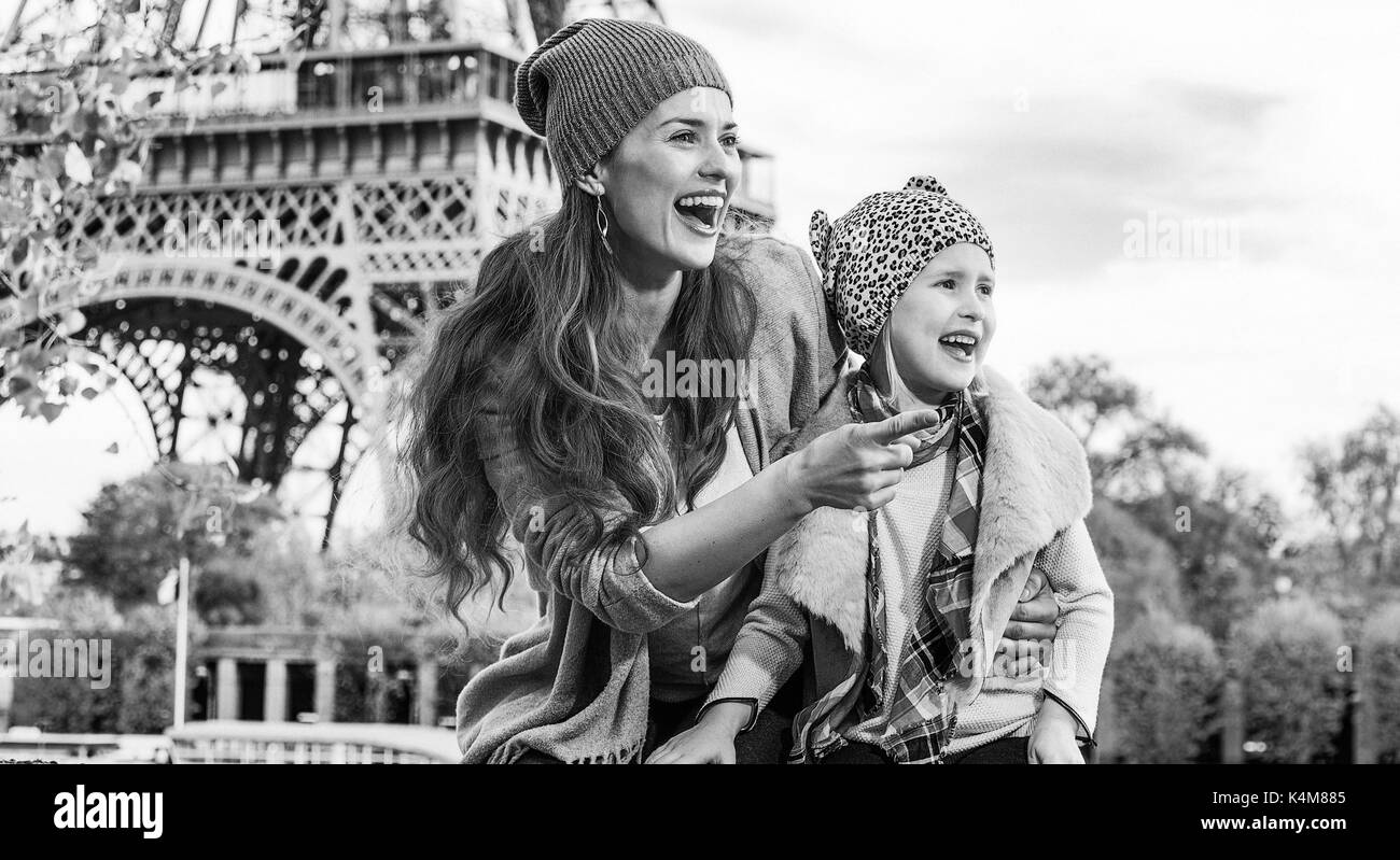 Fughe d'autunno a Parigi con la famiglia. Felice madre e figlia turisti sul terrapieno in parigi, francia puntando su qualcosa mentre è seduto sul par Foto Stock