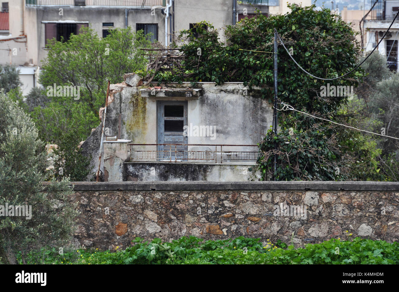 Vecchia casa abbandonata recuperato dalla natura. Urbano e rovinare la pianta infestata da erbacce. Foto Stock