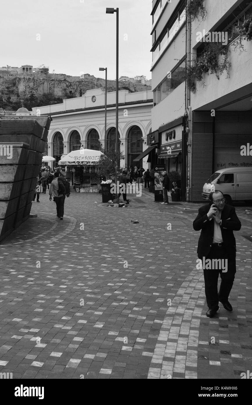 ATHENS, Grecia - 24 Aprile 2015: l'uomo parlando al telefono cellulare e la folla di persone in piazza Monastiraki sotto l'acropoli nel centro di Atene, Grecia. Foto Stock