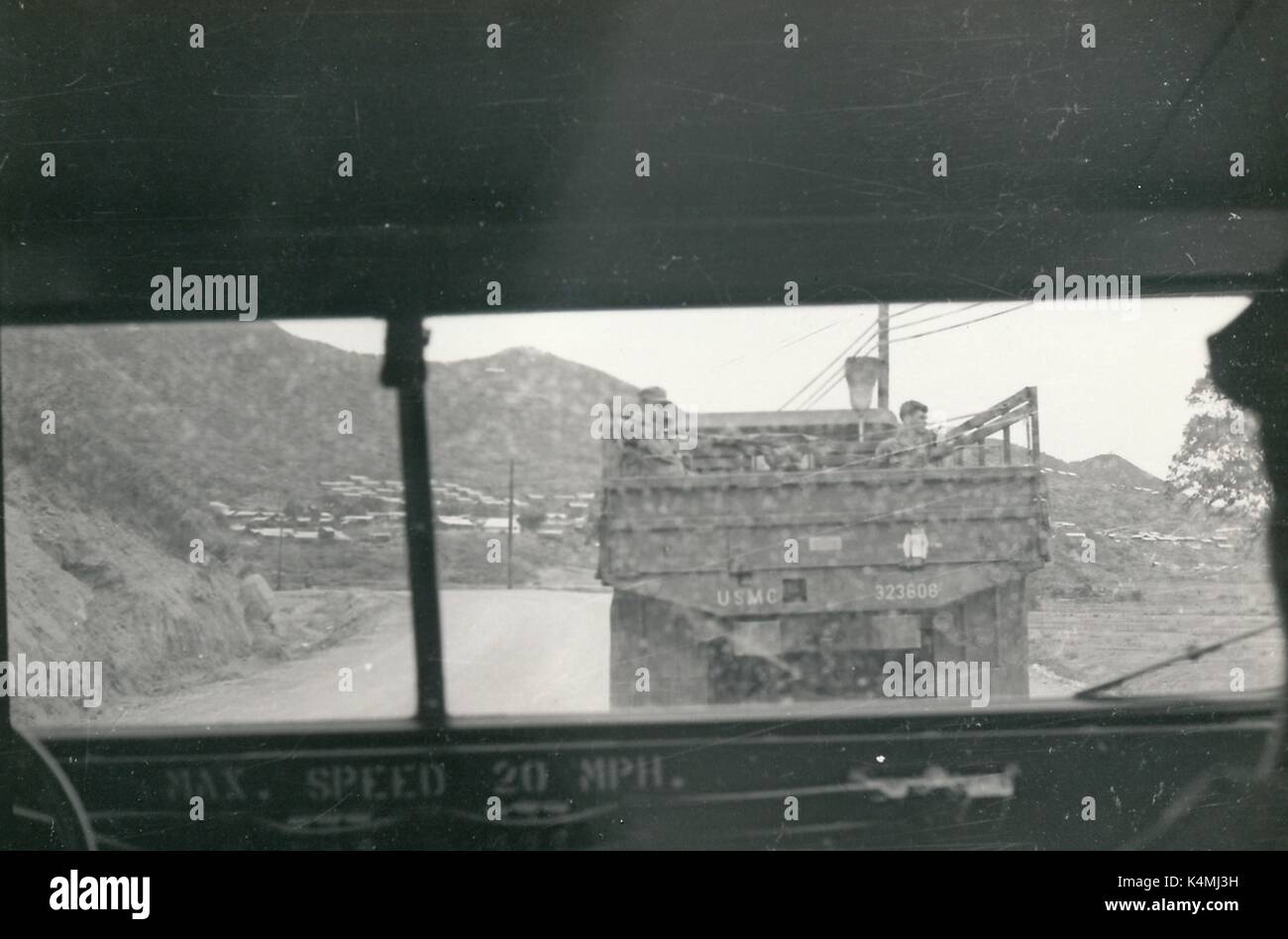 Un corpo della marina degli Stati Uniti veicolo militare con diversi soldati è visibile la guida con una strada in discesa su una pattuglia durante la guerra del Vietnam, visto dalla finestra di un altro veicolo militare, 1968. Foto Stock