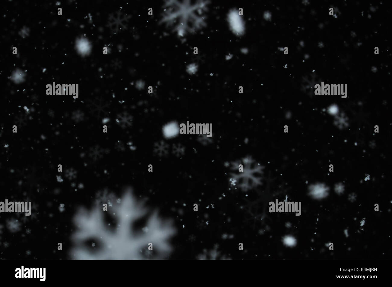 Neve sul cielo notturno abstract la sfocatura dello sfondo. I fiocchi di neve bokeh effetto. Foto Stock
