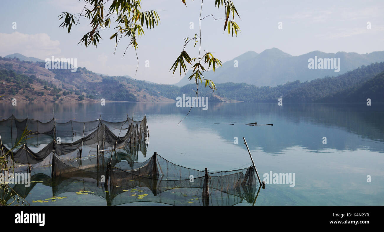 Lakeside a Pokhara con la rete da pesca con la gamma della montagna Foto Stock