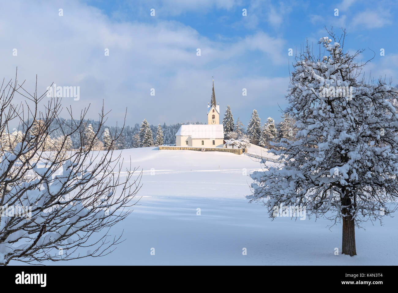 Il sole illumina la chiesa di versam dopo una nevicata, versam, safiental, surselva, Grigioni, Svizzera, Europa Foto Stock
