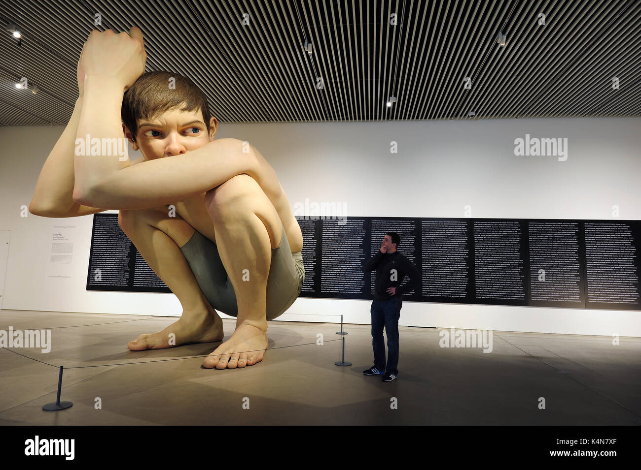 Un uomo guarda al Ron Mueck's Boy a ARoS Aarhus Kunstmuseum ad Aarhus in Danimarca. Foto Stock