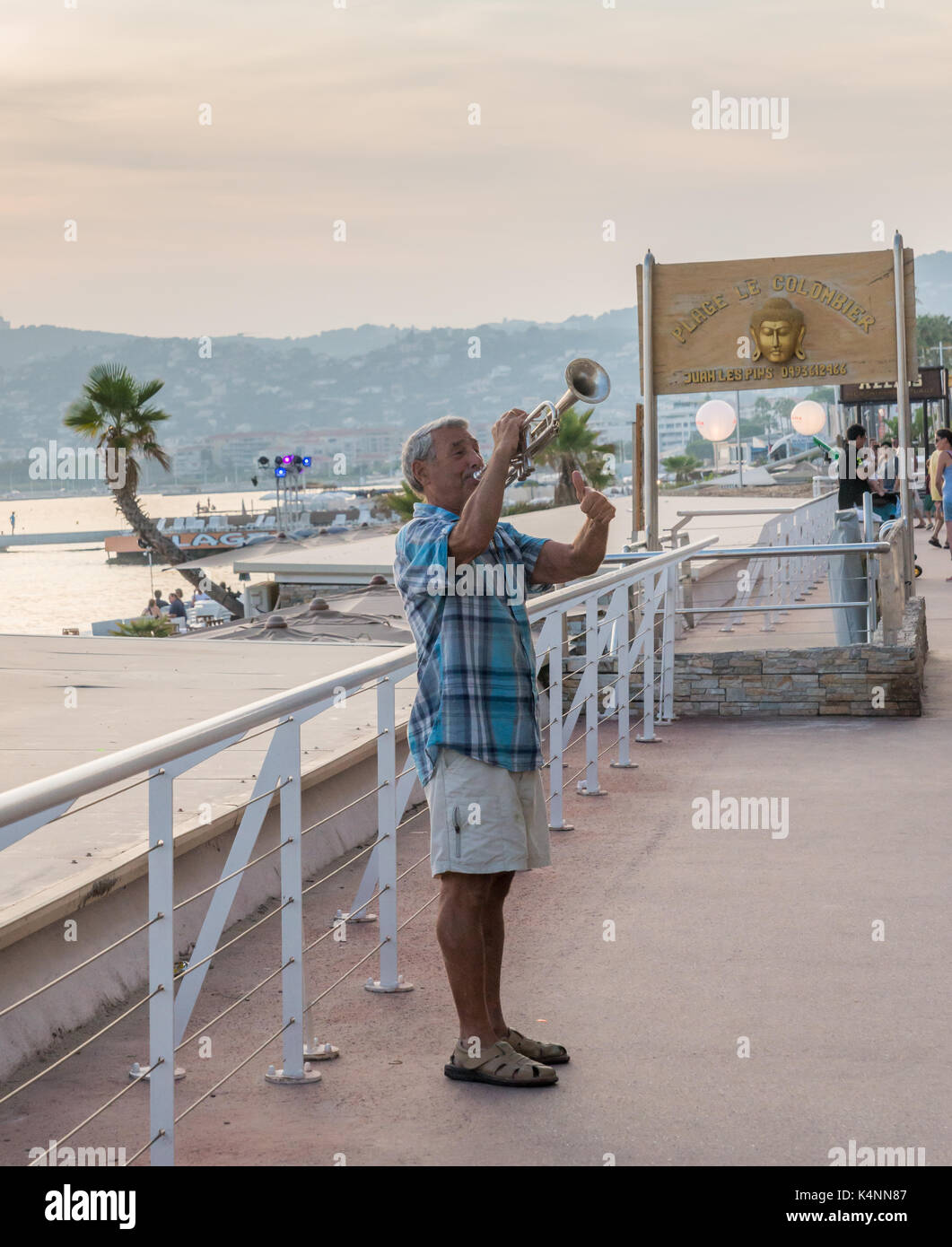 Un uomo gioca un sassofono in pubblico in Juan les Pins, Francia. La città ospita un famoso jazz festival ogni anno in estate. Foto Stock