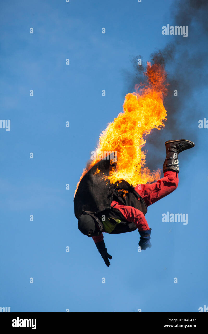 Stuntman saltando da una piattaforma sul fuoco e fiamme durante il motore di vapore al rally Astle park Chelford nel Cheshire Foto Stock