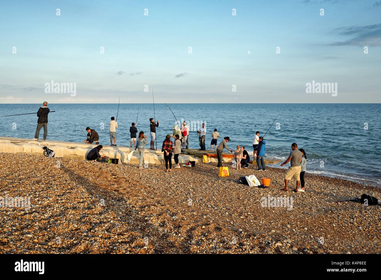 Gruppo misto di persone di pesca sulla spiaggia di Hastings SUSSEX REGNO UNITO Foto Stock